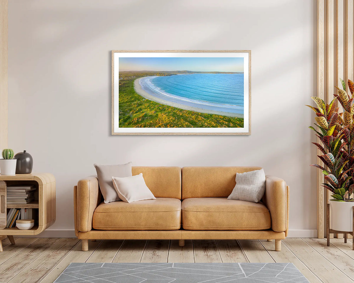 Broulee Blues. Framed wall art print of Broulee beach, with a timber frame, hung above a leather couch. 