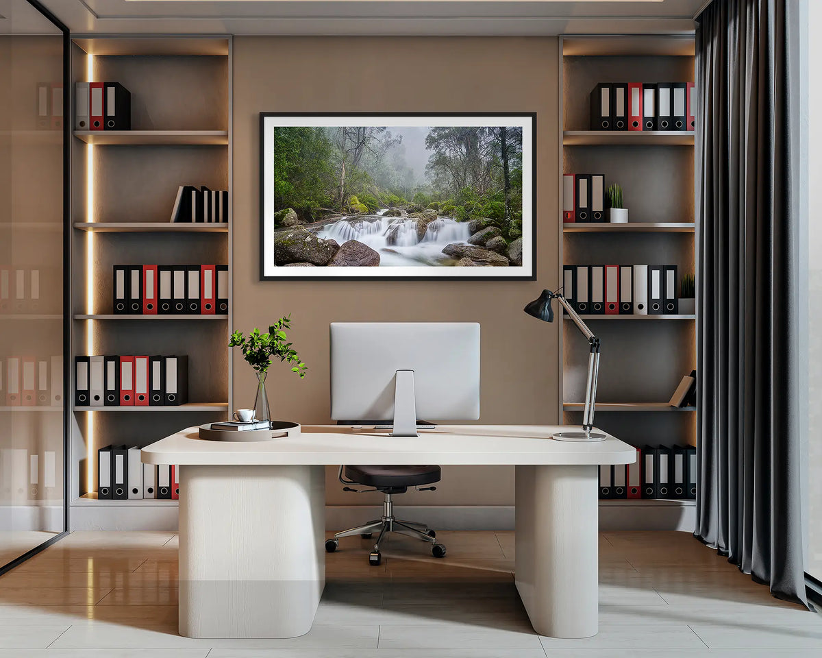 Buffalo Cascade. Wall art print of Eurobin Creek, Mount Buffalo, with a black frame, hanging behind a desk in a corporate office. 