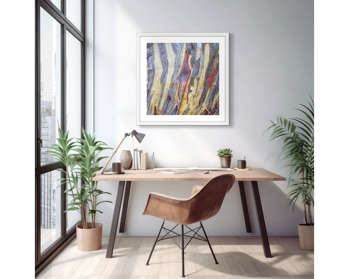 Buller Bark. Abstract snow gum wall art print with a white frame, hung on an apartment wall above a small desk. 
