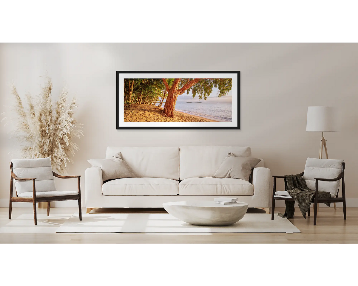 Cairns Escape. Far north Queensland wall art, with a black frame, above a couch. 