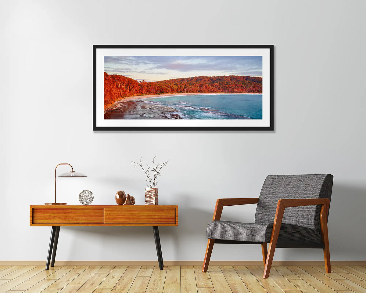 Calm at Depot Beach. Framed wall art print of a sunrise at Depot Beach, South Coast, with a black frame and hung above a side table.