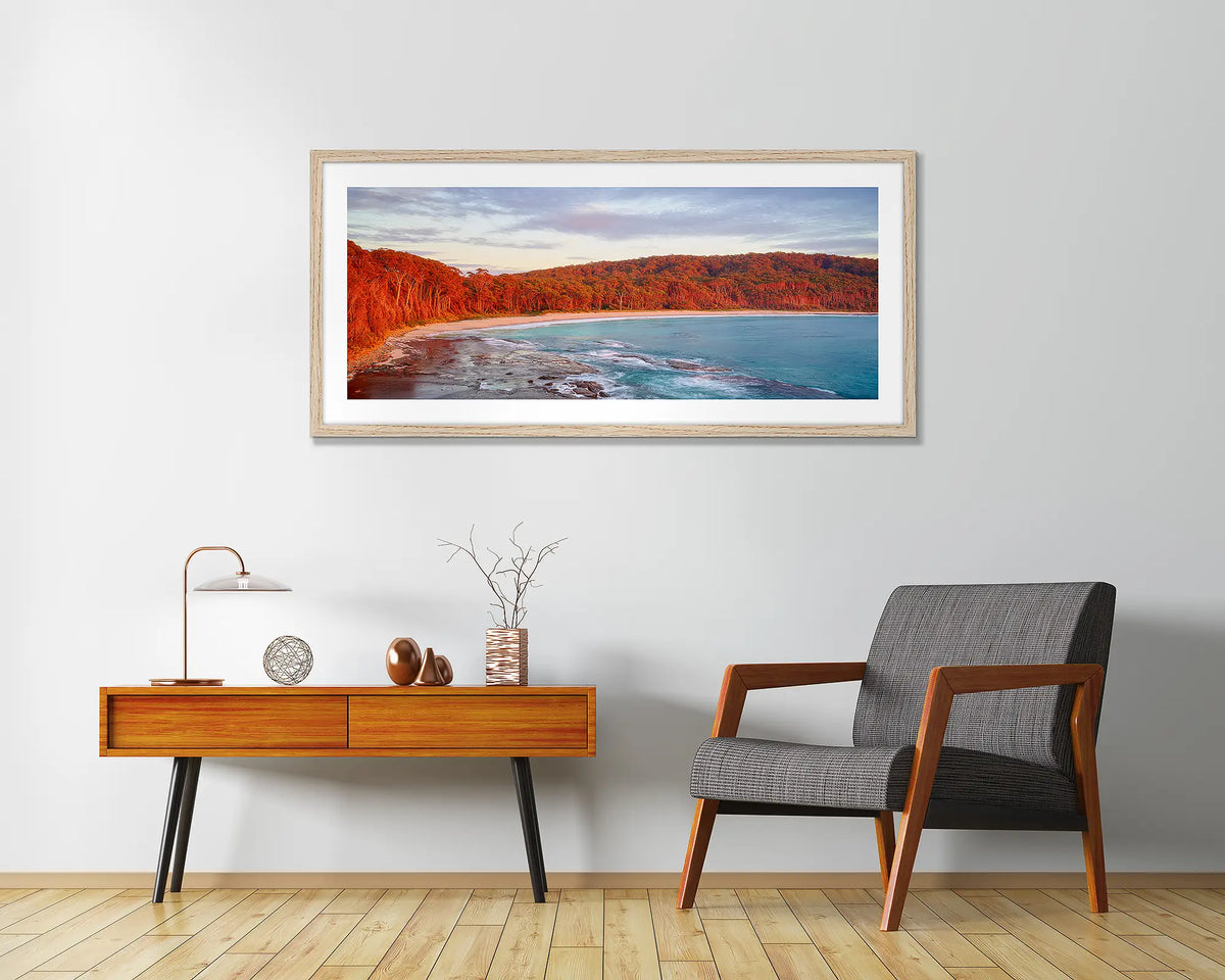 Calm at Depot Beach. Framed wall art print of a sunrise at Depot Beach, South Coast, with a timber frame and hung above a side table.