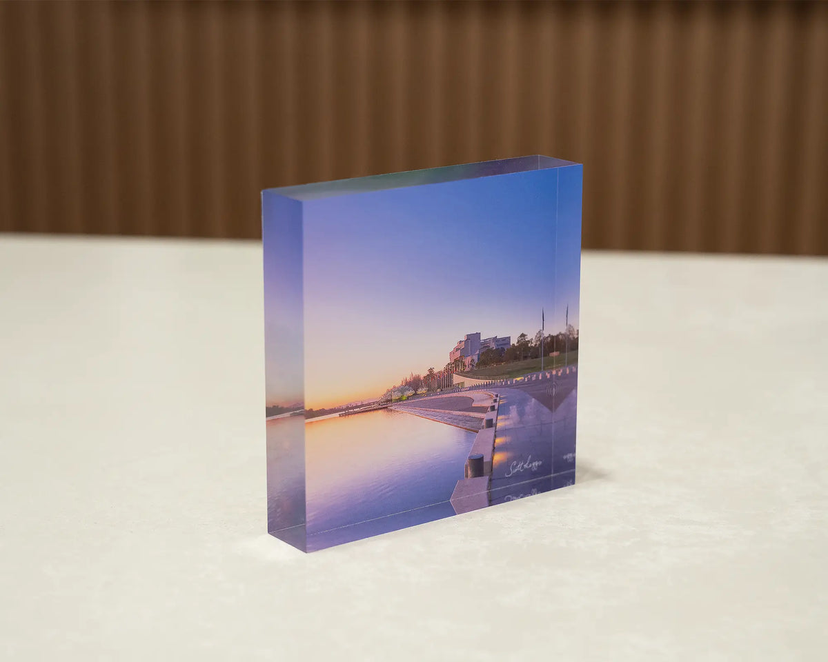 Canberra Awakes. Acrylic block of sunrise over Lake Burley Griffin, sitting on a desk.