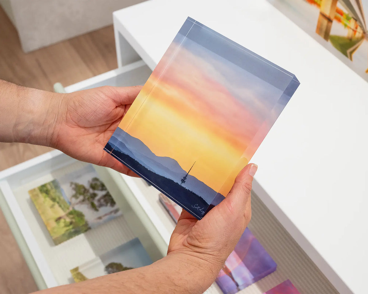 Canberra Beacon. Acrylic block of a summer sunset over Black Mountain Tower, held in hands.