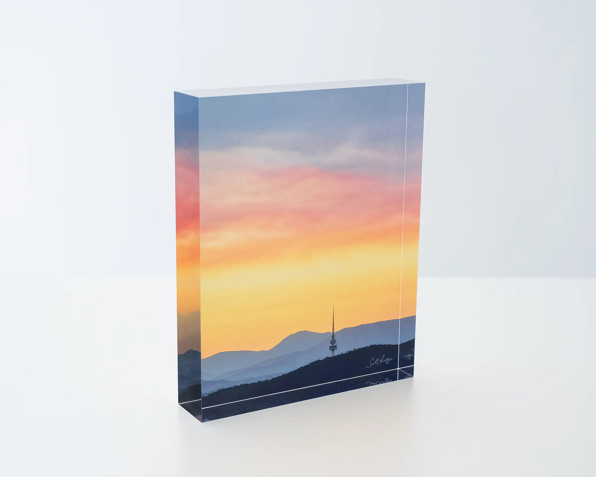 Canberra Beacon. Acrylic block of sunset over Black Mountain Tower, sitting on a desk.