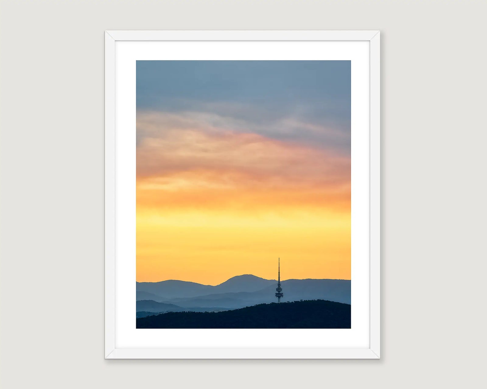 Framed artwork of a sunset with a silhouette of a Black Mountain Tower. 