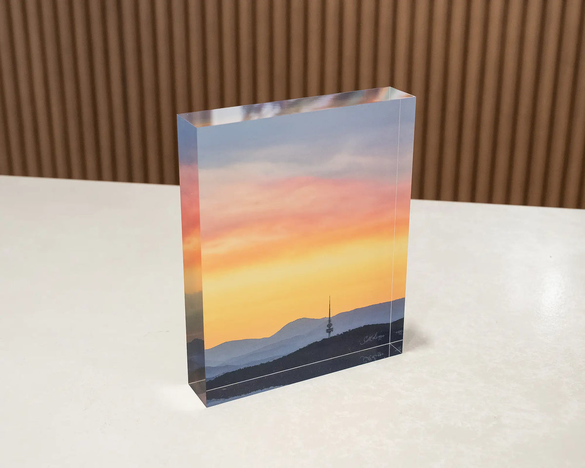 Canberra Beacon. Acrylic block of a summer sunset over Black Mountain Tower, sitting on a desk.