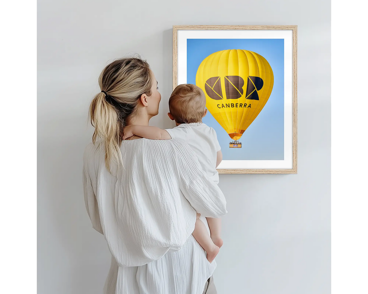 Canberra Bubble. Hot air balloon artwork with a timber frame, being admired by a mother and baby. 