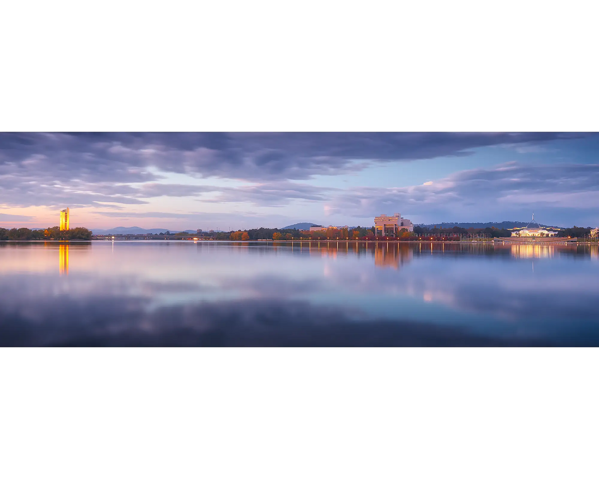 Still waters and cloudy skies moments before sunrise over Lake Burley Griffin.