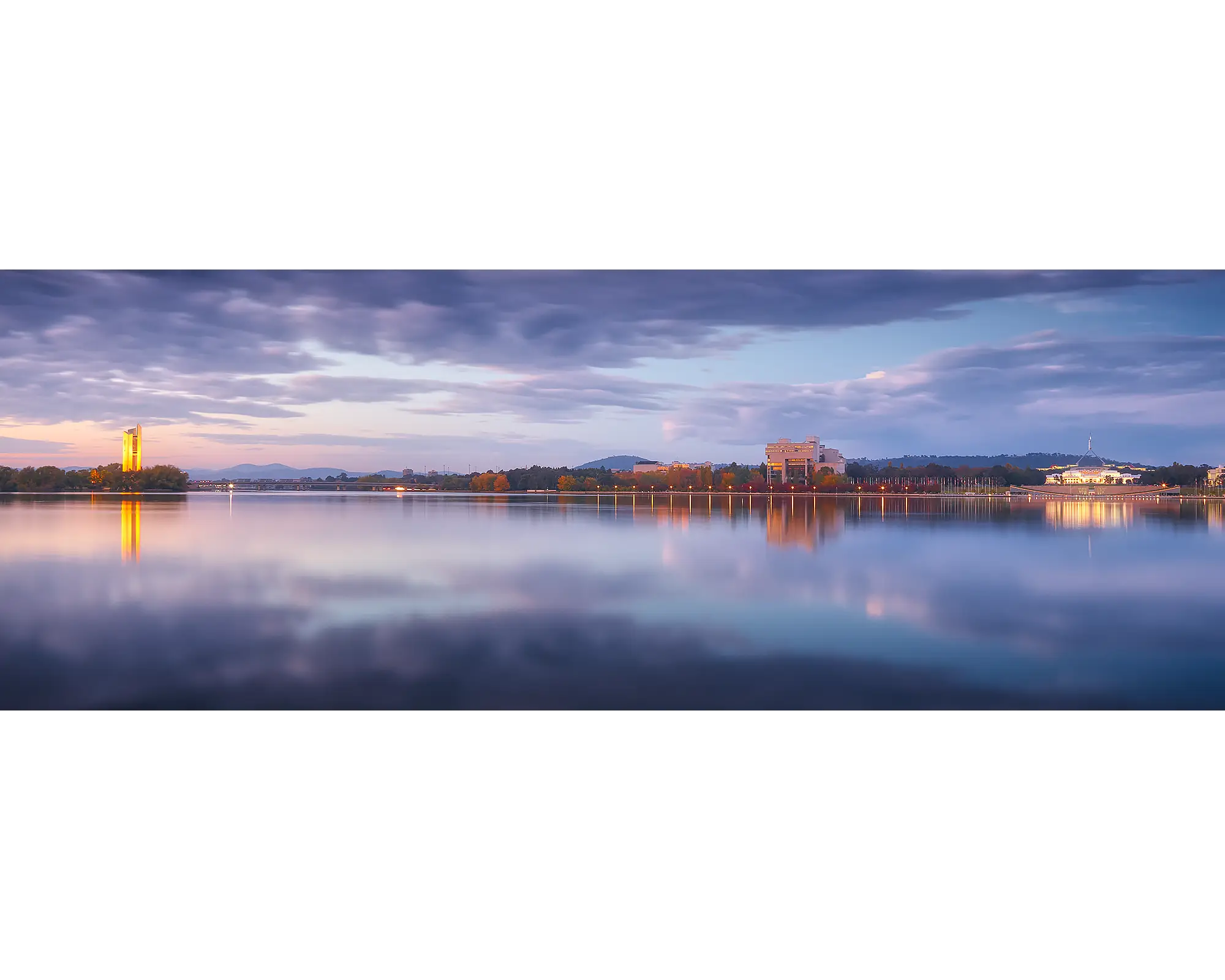 Still waters and cloudy skies moments before sunrise over Lake Burley Griffin.