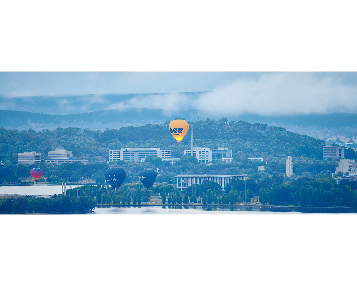 Canberra Rising. Hot air balloons rising over prominent Canberra landmarks with early morning fog.