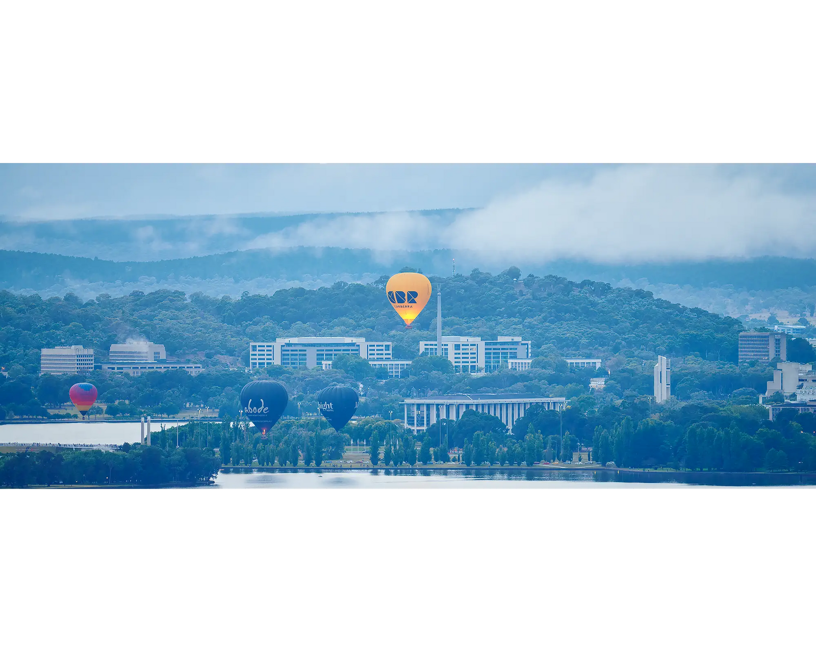 Canberra Rising. Hot air balloons rising over prominent Canberra landmarks with early morning fog.