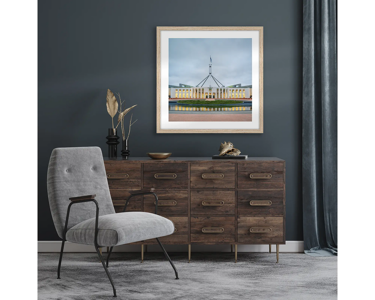 Capital Hill. Wall art pint with timber frame of Parliament House, Canberra, hung in a room with dark walls.