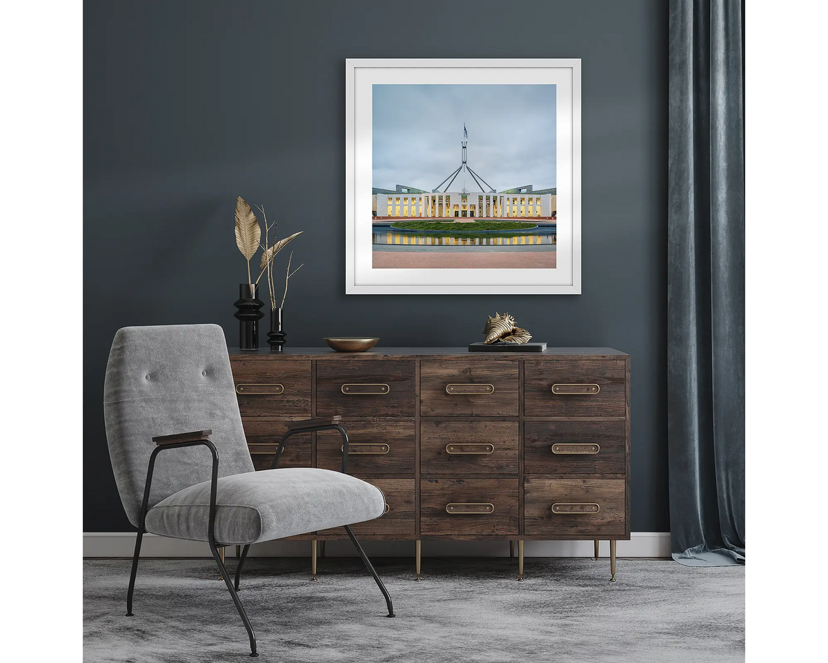 Capital Hill. Wall art pint with white frame of Parliament House, Canberra, hung in a room with dark walls.