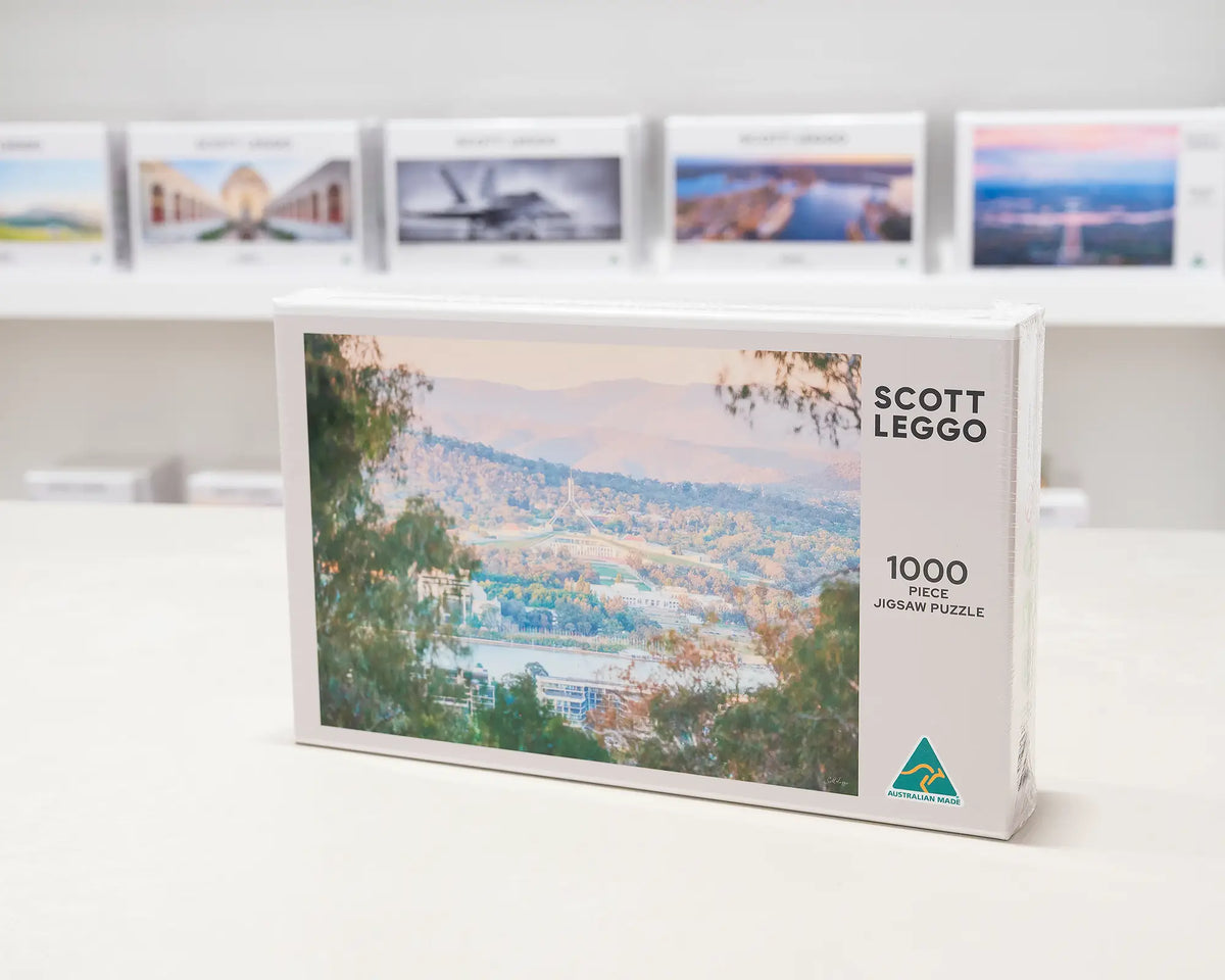 Capital View 1000 piece jigsaw puzzle box sitting in front of other jigsaw puzzles. 