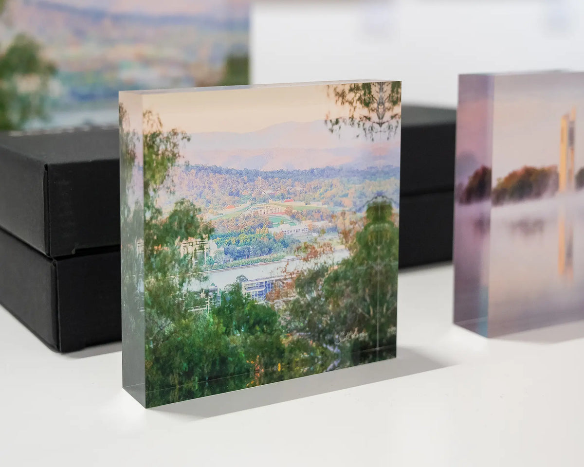 Capital View. Acrylic block views of Parliament House through gum trees, on display in gallery with Canberra acrylic blocks.