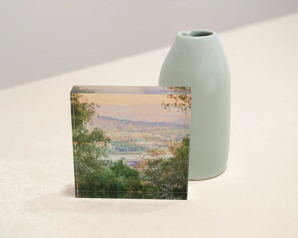 Capital View. Acrylic block with views of Canberra, sitting on a desk styled with small vase.