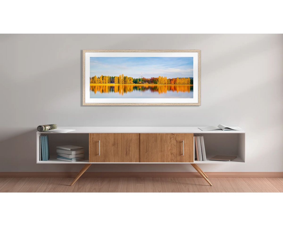 Changing Seasons. Wall art print with a timber frame, of an autumn sunset, beside lake Burley Griffin, Canberra, hung above a side table. 