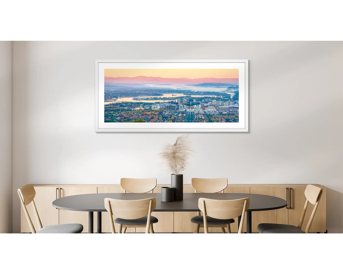 Civic Autumn. Photographic wall art print of an autumn sunrise over Canberra, framed in a white frame and hung on a dining room wall. 