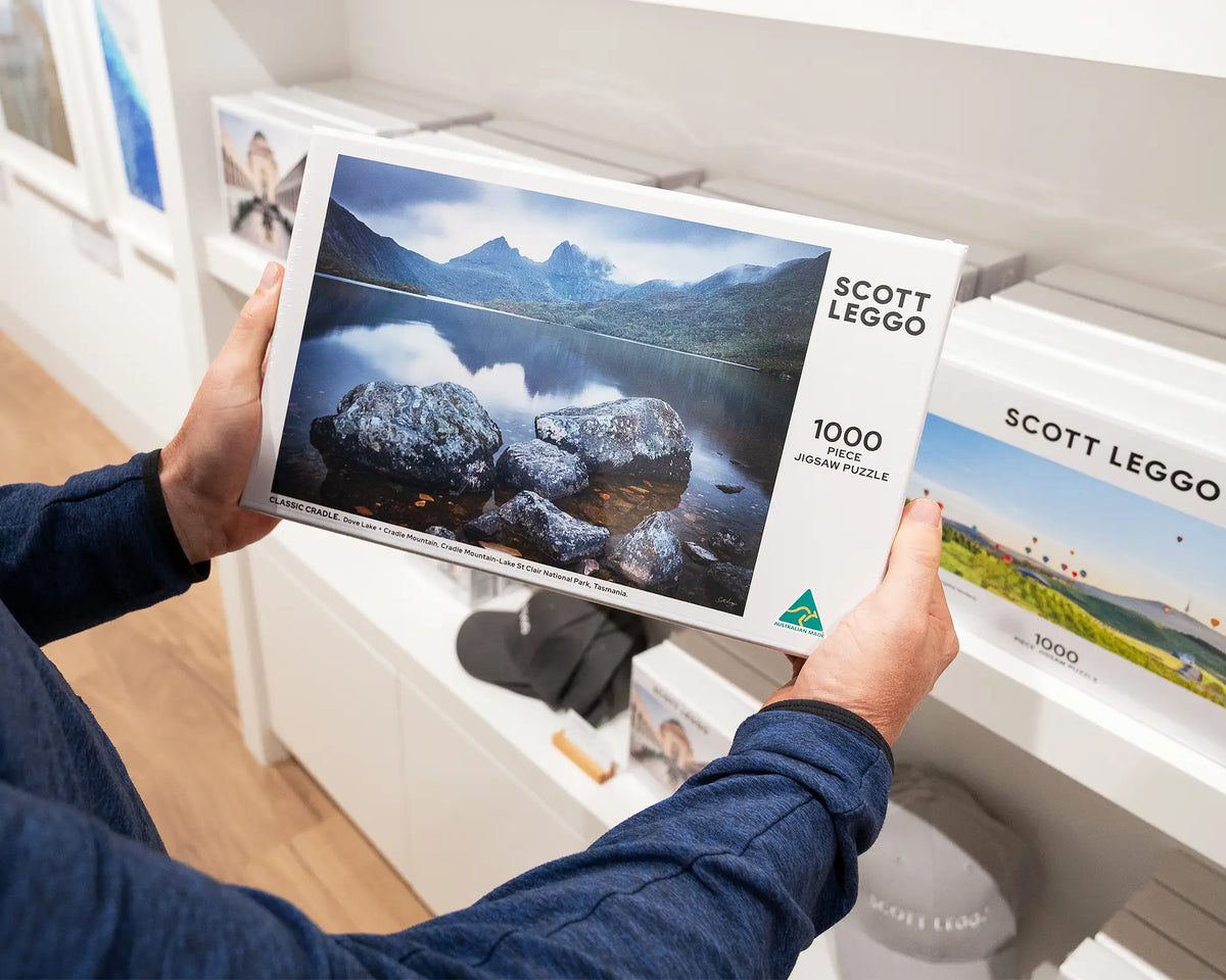 Classic Cradle. 1000 piece jigsaw puzzle of Cradle Mountain, Tasmania, held in hands.