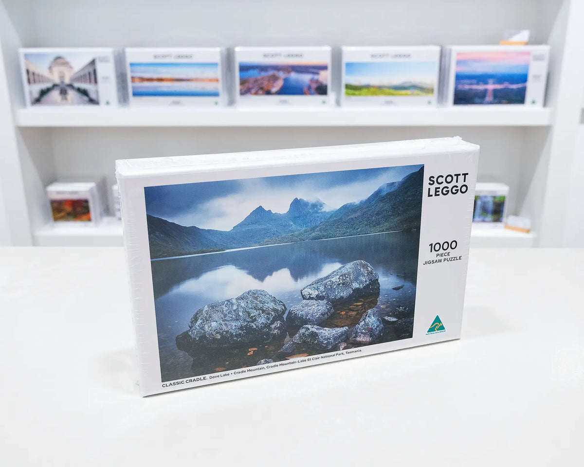 Classic Cradle. 1000 piece jigsaw puzzle of Cradle Mountain, Tasmania, on gallery desk with puzzles behind.