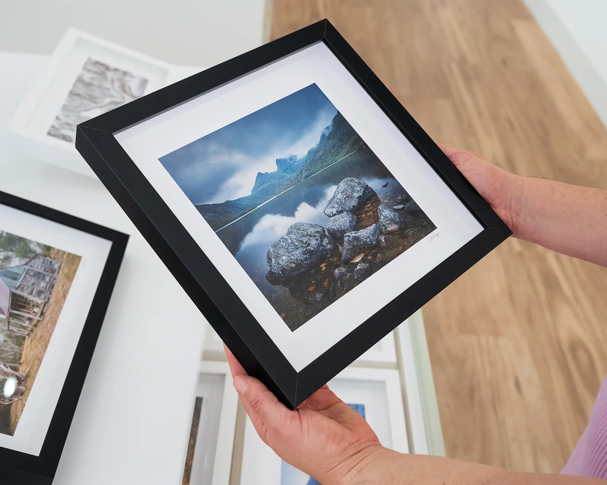 Classic Cradle. Cradle Mountain Tasmania, small print with black frame, held in hands.