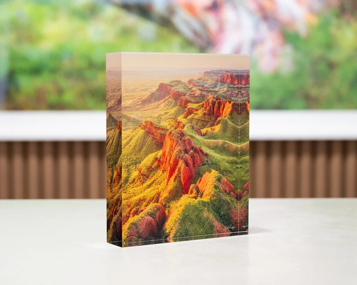 Classic Kimberley. Acrylic block Ragged Range, Western Australia, on desk with large SCOTT LEGGO artwork in background.