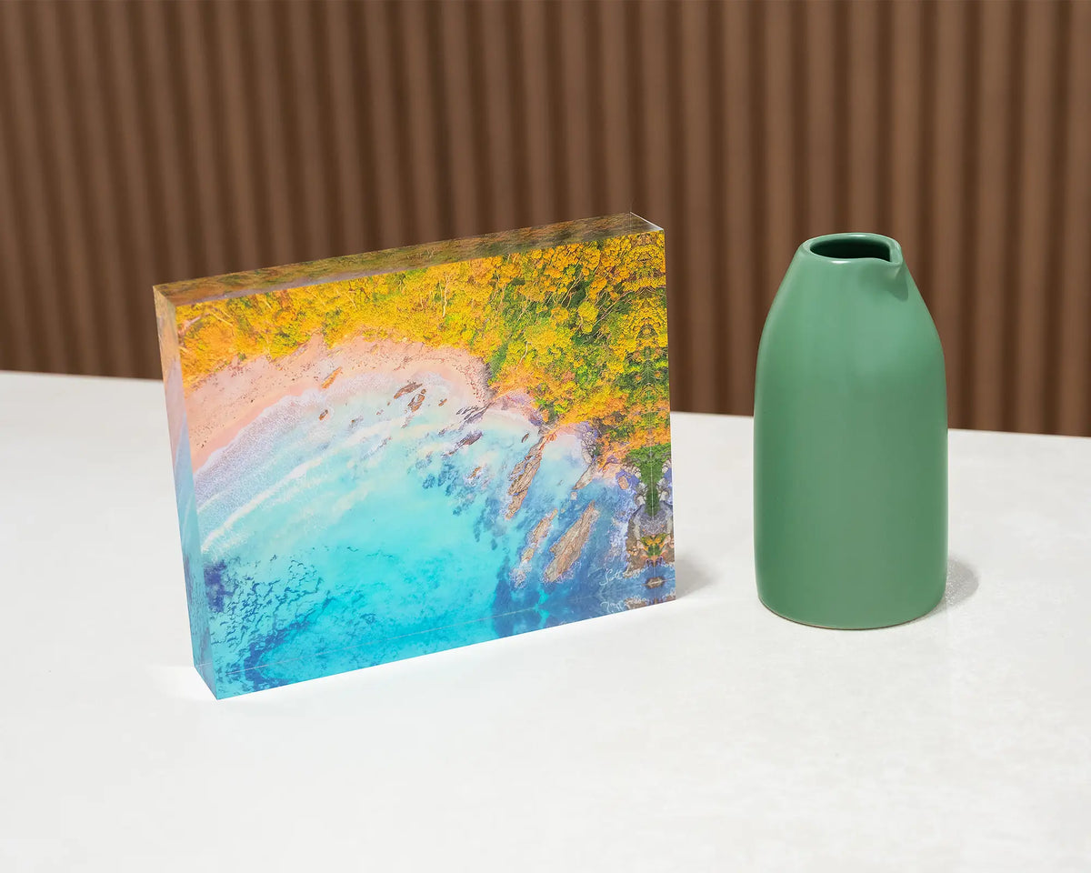 Coastal Bliss. Acrylic block of sunrise at Lilli Pilli Beach, New South Wales, on desk styled with a small vase.