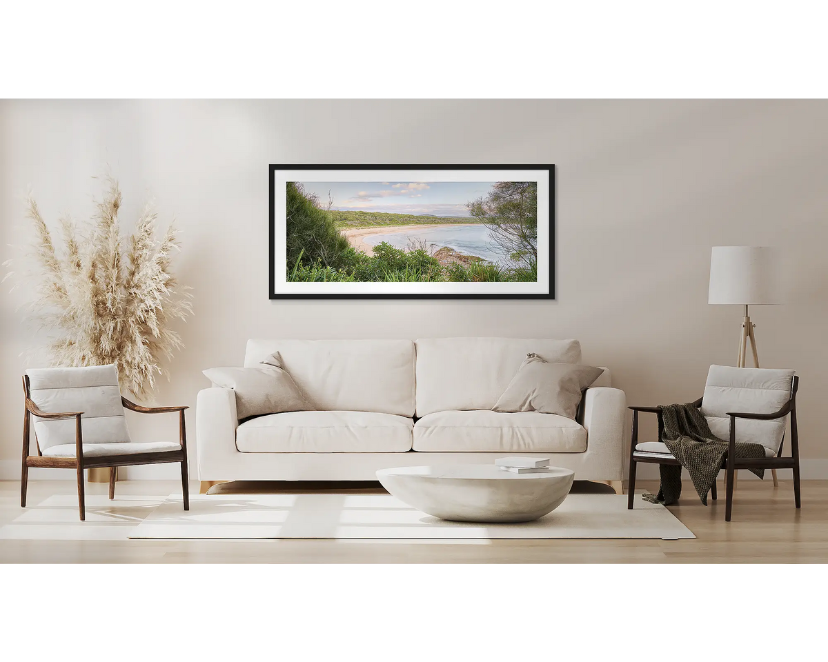 Coastal Retreat. South coast wall art, with a black frame, above a couch. 
