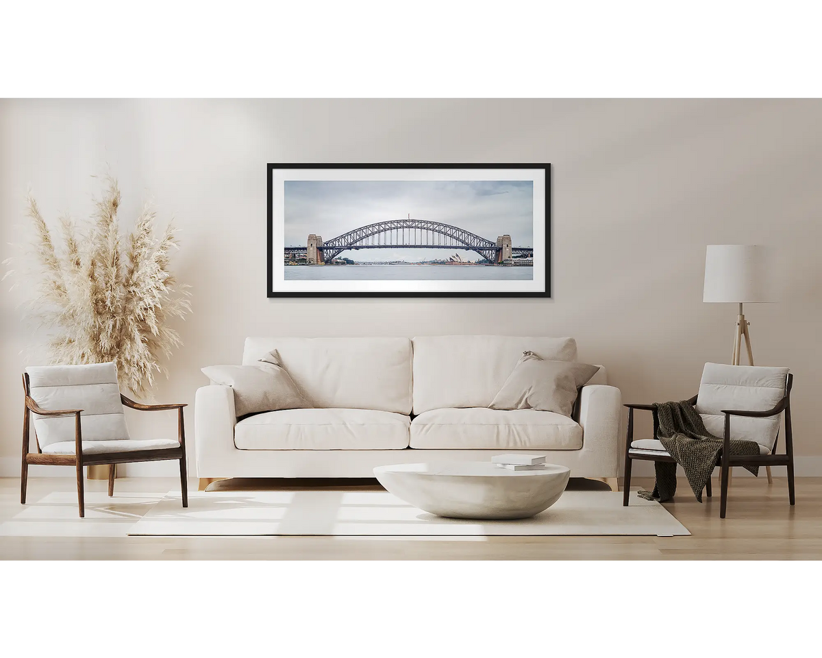 Coat Hanger. Sydney Harbour Bridge wall art, with a black frame, above a couch. 