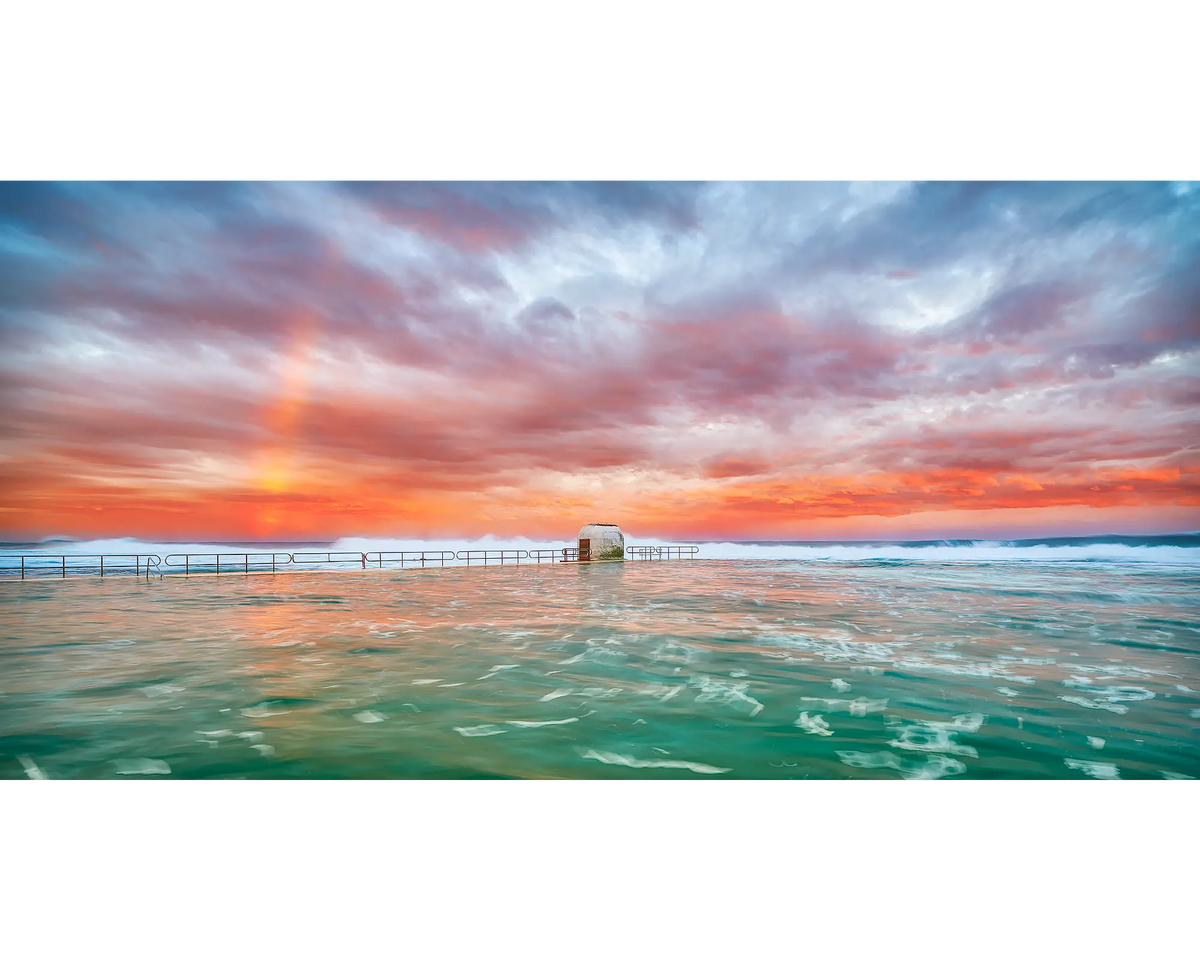 A rainbow and colourful clouds over Merewether Ocean Baths, Newcastle, NSW.