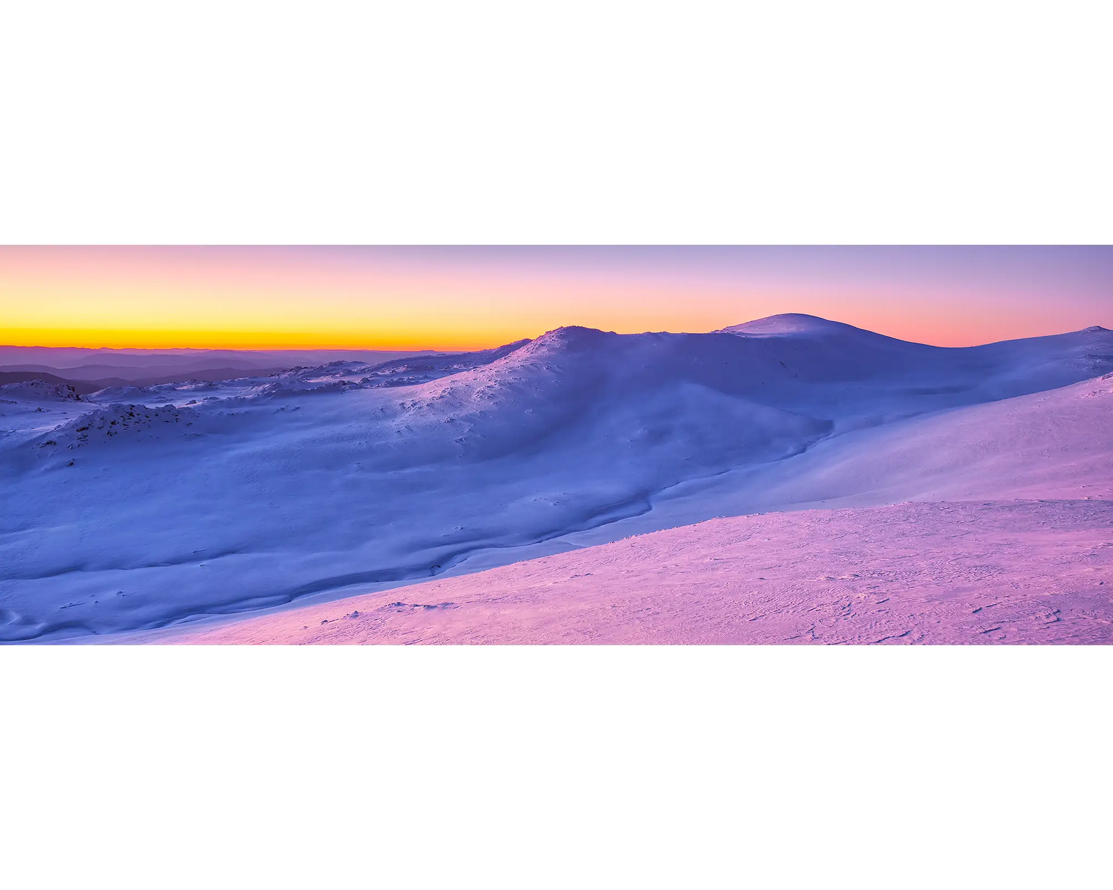 A colourful sunset over Mount Kosciuszko covered in snow. 