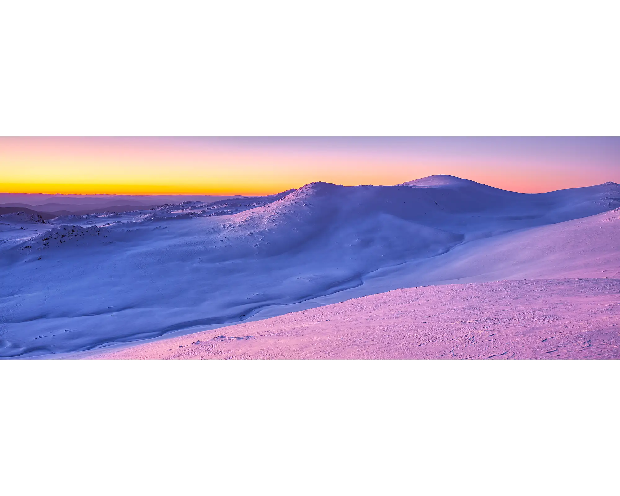 A colourful sunset over Mount Kosciuszko covered in snow. 