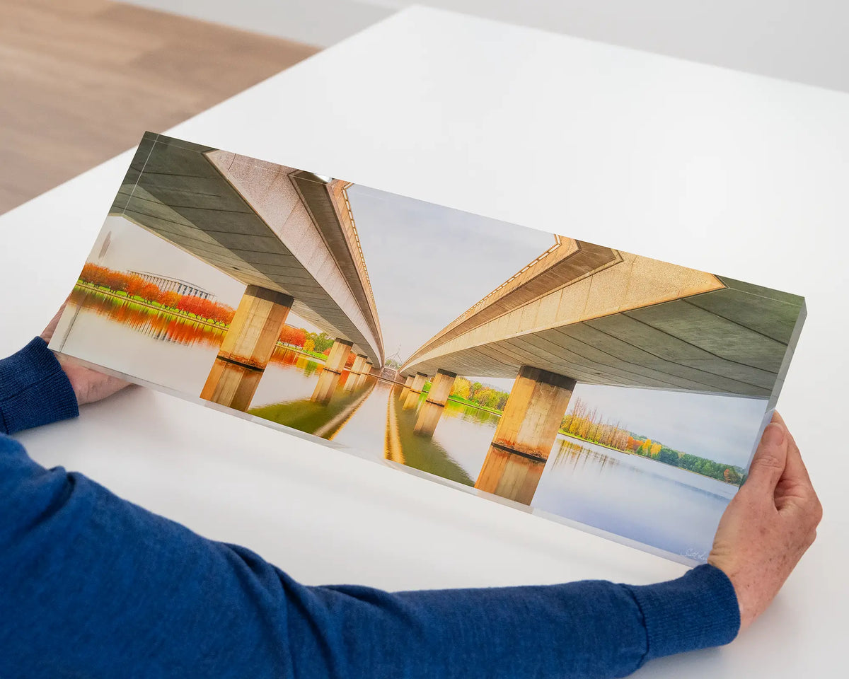 Convergent. Acrylic block of Commonwealth Avenue Bridge in Autumn at sunrise, being hand held.