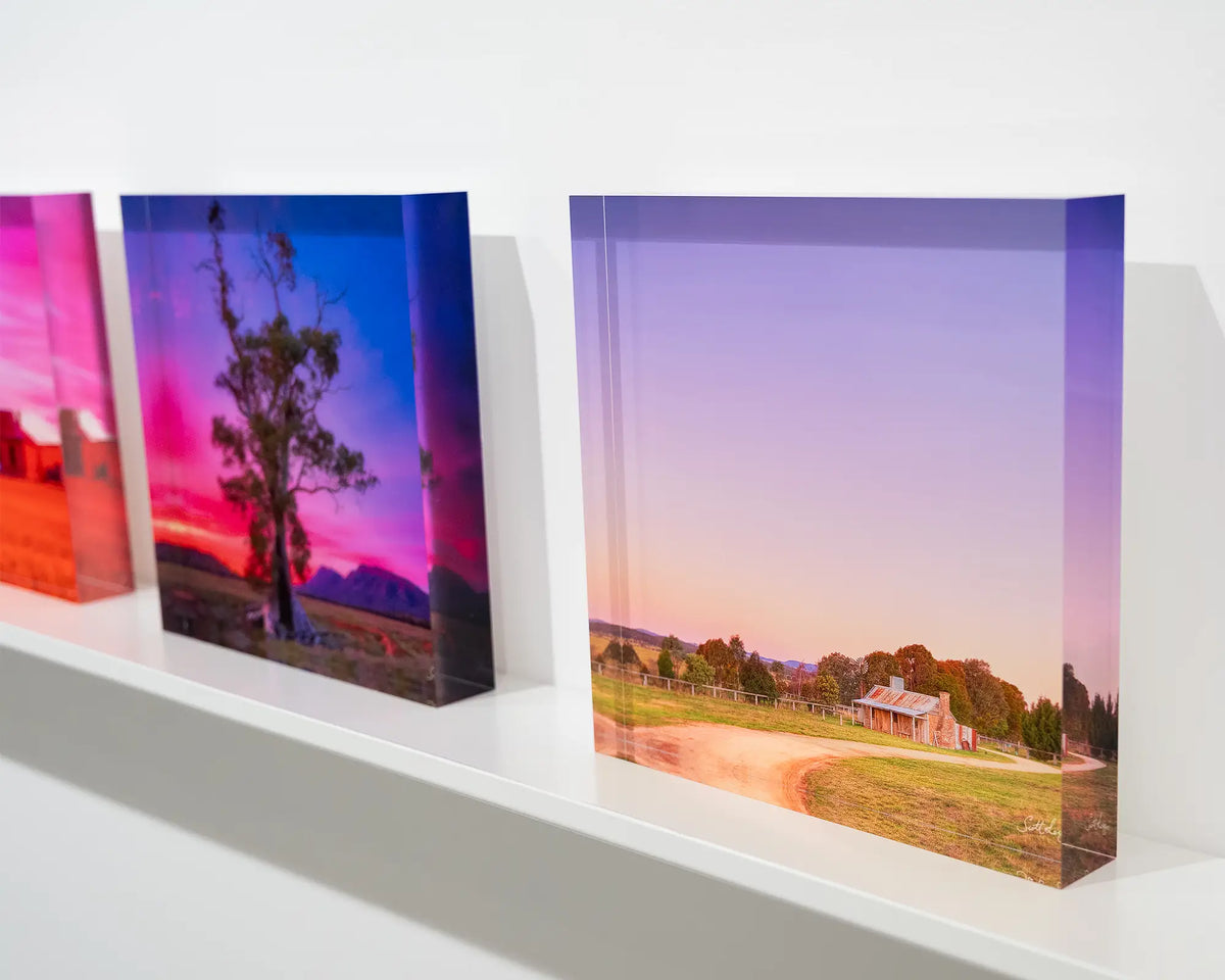 Country Charm. Acrylic block sunset at a Bungendore farmhouse, New South Wales, on gallery shelf with more acrylic blocks.