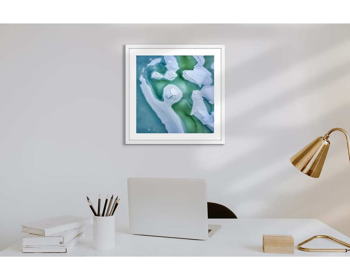 Cracked. Wall art print of snow covered Snowy River, with a white frame in a work from home office.  