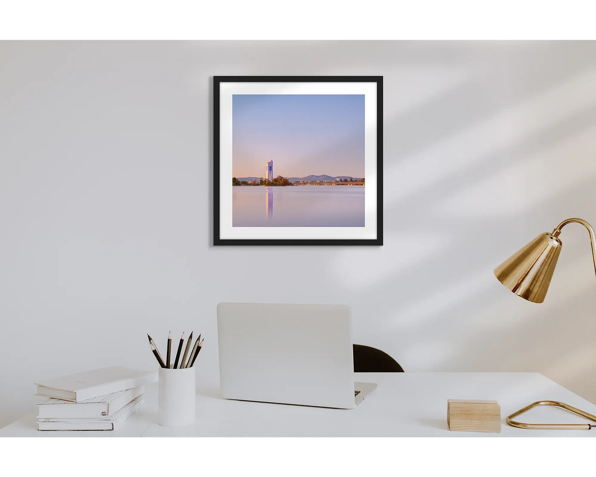 Crisp. Wall art print of a sunrise over the Carillon, with a black frame in a work from home office.  
