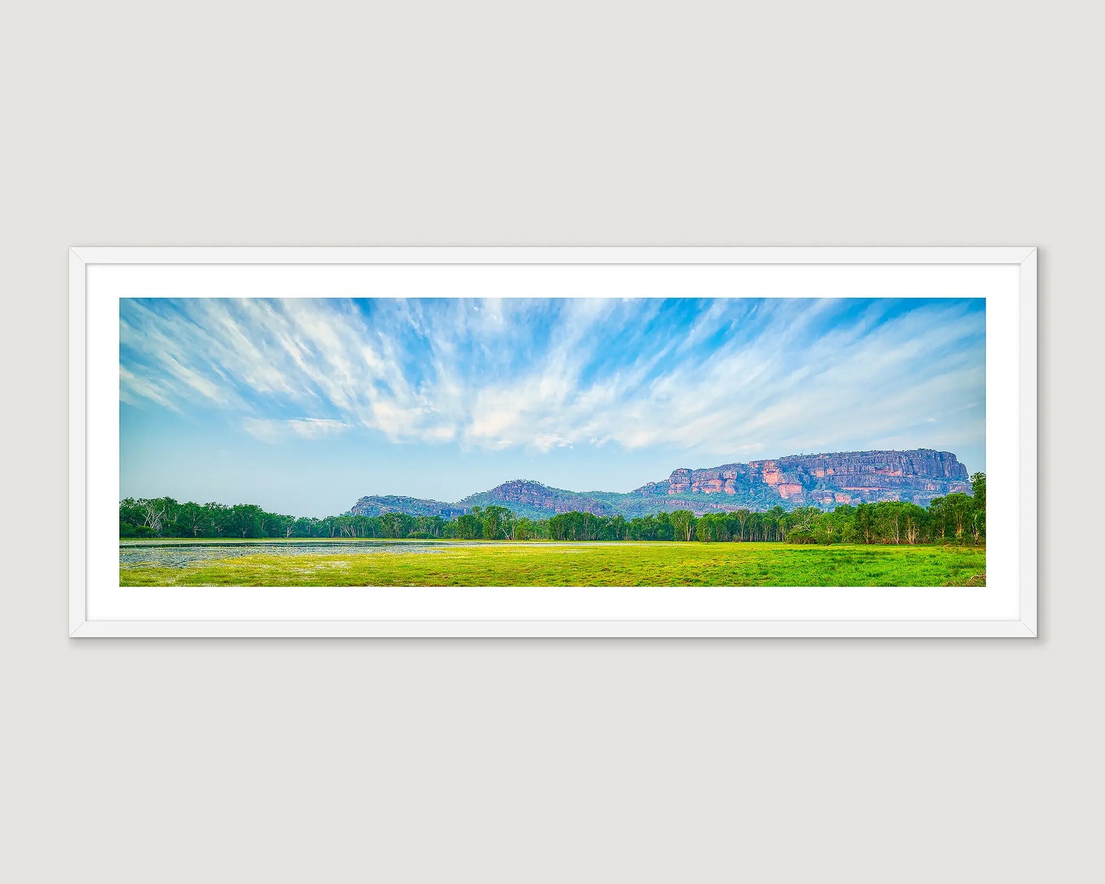 Framed photographic print of Anbangbang Billabong flanked by bushland with Nourlangie Rock in view. 