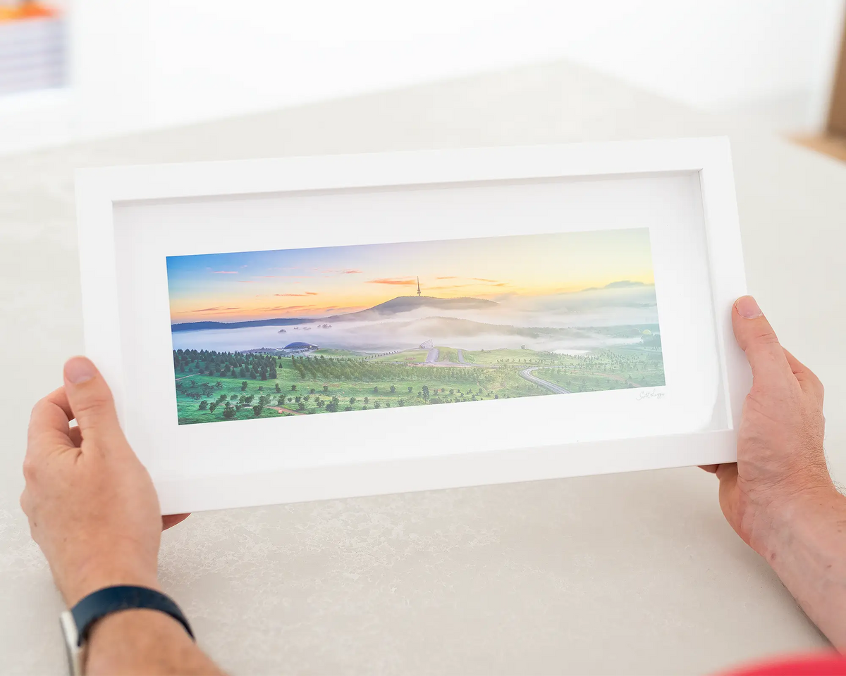 Dawn At The Arboretum. Canberra small framed print being held in held.