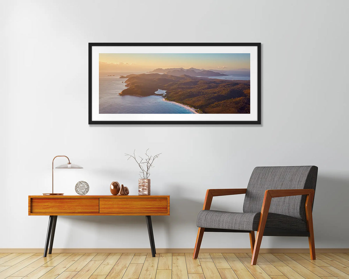 Dawn Over Freycinet. Framed wall art print of a sunrise over Freycinet National Park, with a black frame hung in an entrance area. 