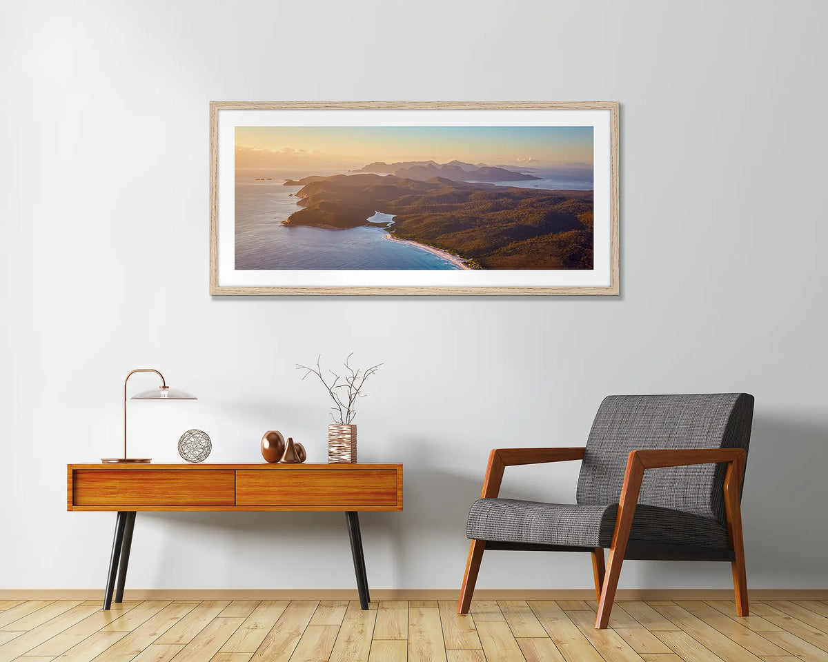 Dawn Over Freycinet. Framed wall art print of a sunrise over Freycinet National Park, with a timber frame hung in an entrance area. 