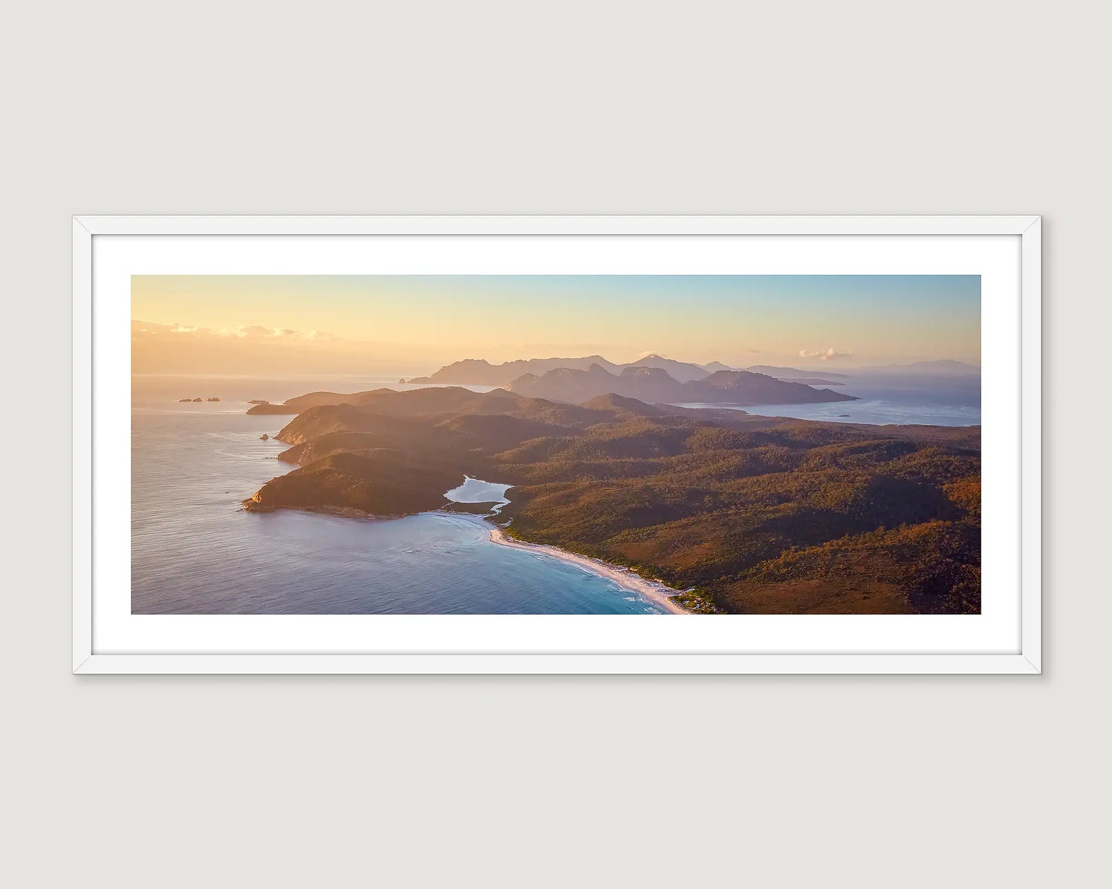 Framed coastal photograph of an aerial view of Freycinet Bay at sunrise. 
