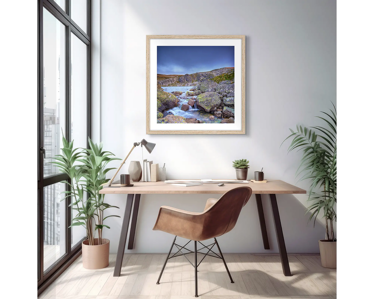 Deep Blue. Wall art print of Blue Lake in Kosciuszko National Park, with a Tasmanian Oak frame, hung above a desk in an apartment.