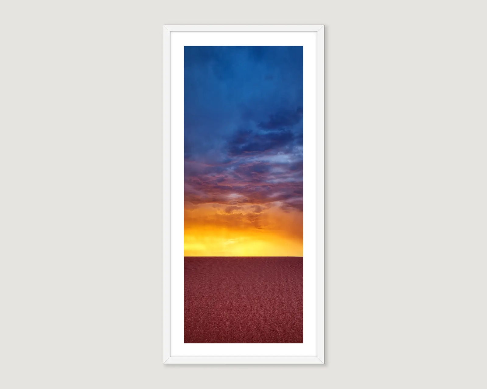Framed photograph of a red desert at sunset and a stormy sky.