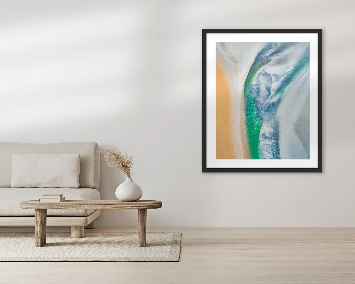 Displacement. Aerial wall art print, with a black frame, in a living room. 
