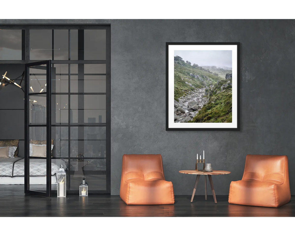 Downstream. Framed wall art print of the Snowy River, with a black frame hung in a loft apartment. 
