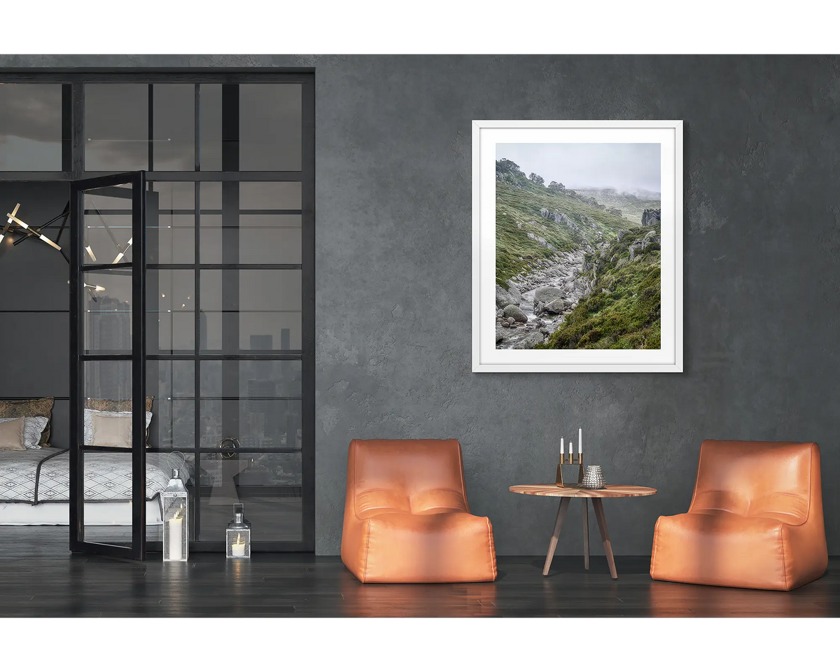 Downstream. Framed wall art print of the Snowy River, with a white frame hung in a loft apartment. 