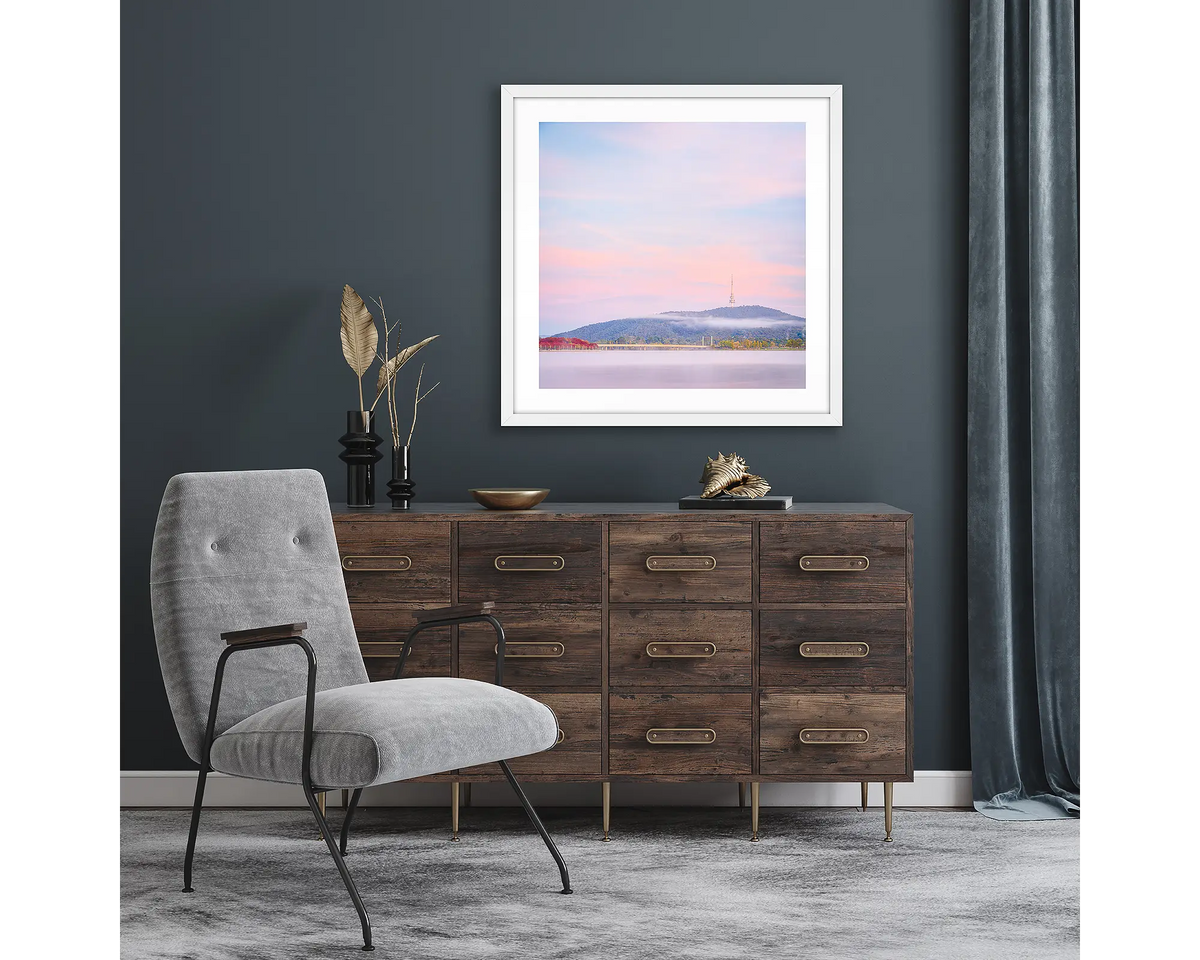 Dreamy Canberra. Framed wall art print of a sunrise over Canberra, with a white frame and hung above a side table