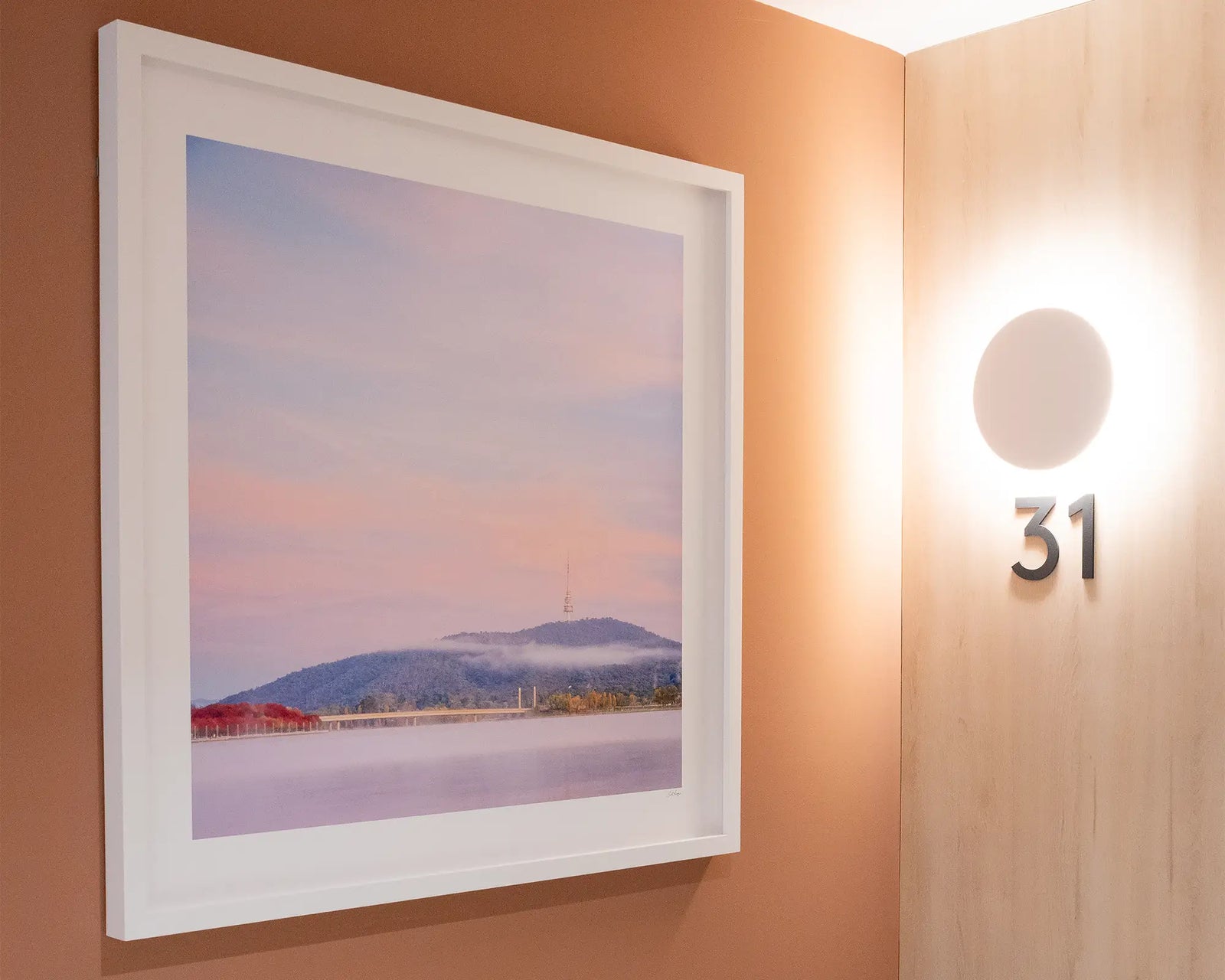 Framed photograph of a fog at sunrise over Lake Burley Griffin with views of red autumn trees and Black Mountain. 