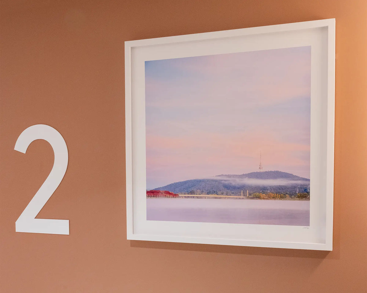 Dreamy Canberra. Sunrise with fog over Lake Burley Griffin, with white frame hung on terracotta coloured wall, second floor commercial space.